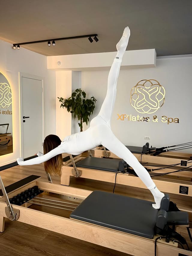 Exercițiu pe Reformer în studioul XPilates, cu întreaga postură vizibilă